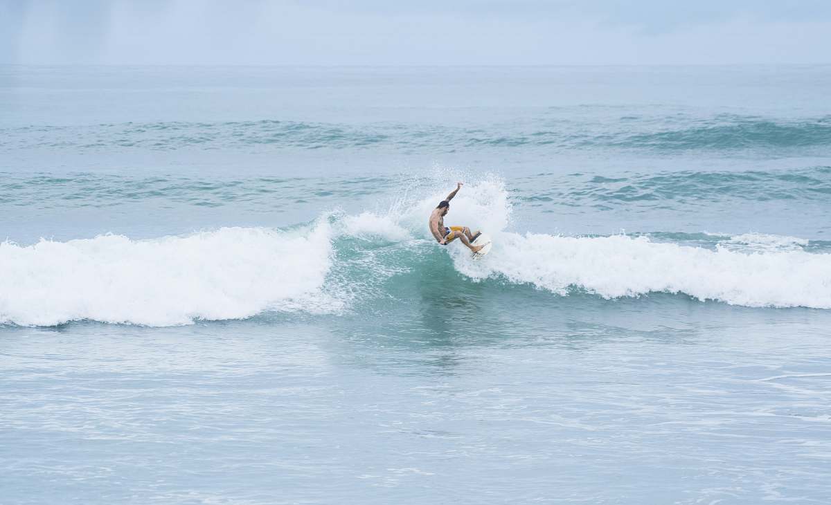 ocean man riding a surfboard facing the waves on the ocean surf