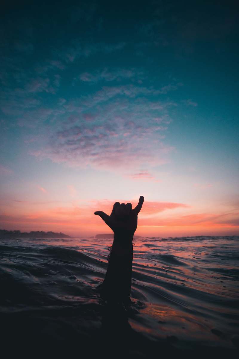 person person lifting his hand from water shaka