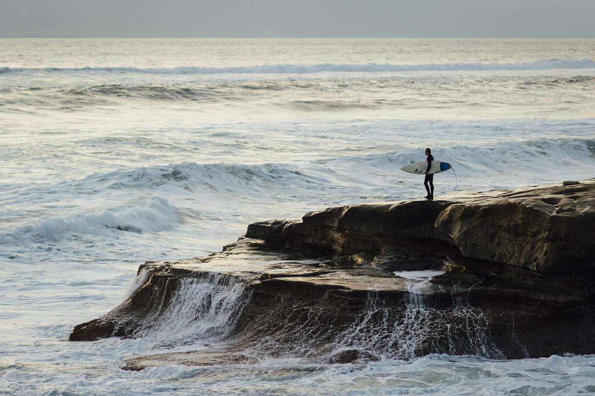 sea person carrying surfboard standing near seashore coast