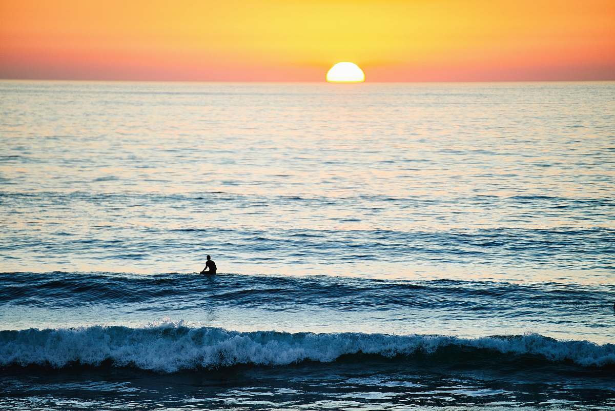 ocean person surfing during sunset surfer