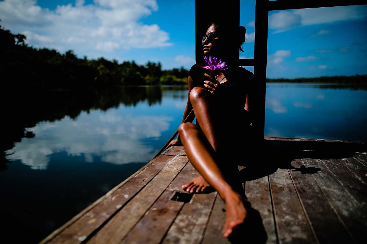tan woman sitting near body of water lady