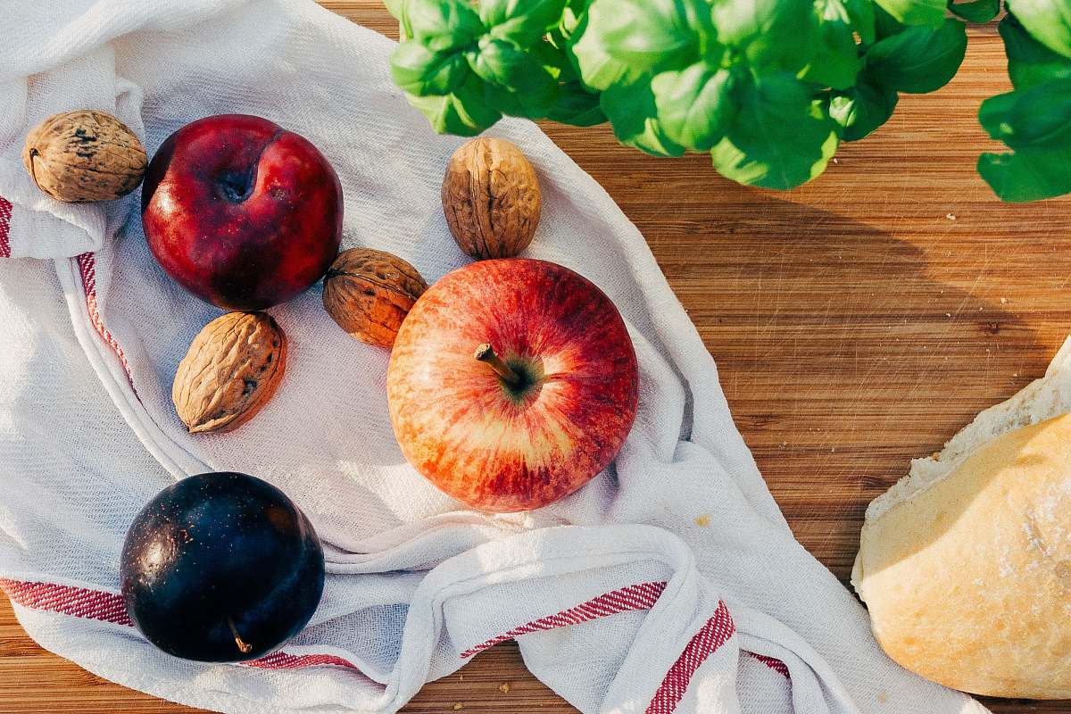walnut two apples and walnuts on white towel plum
