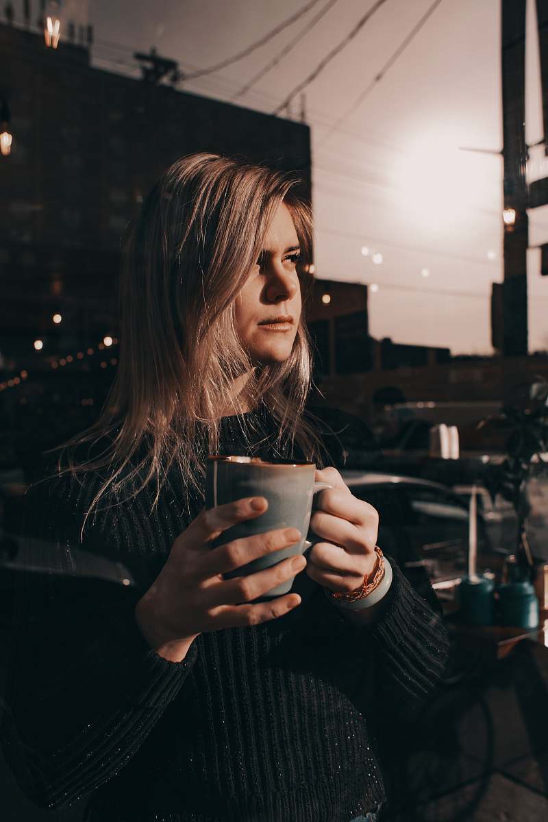 person woman in black top holding cup of coffee restaurant