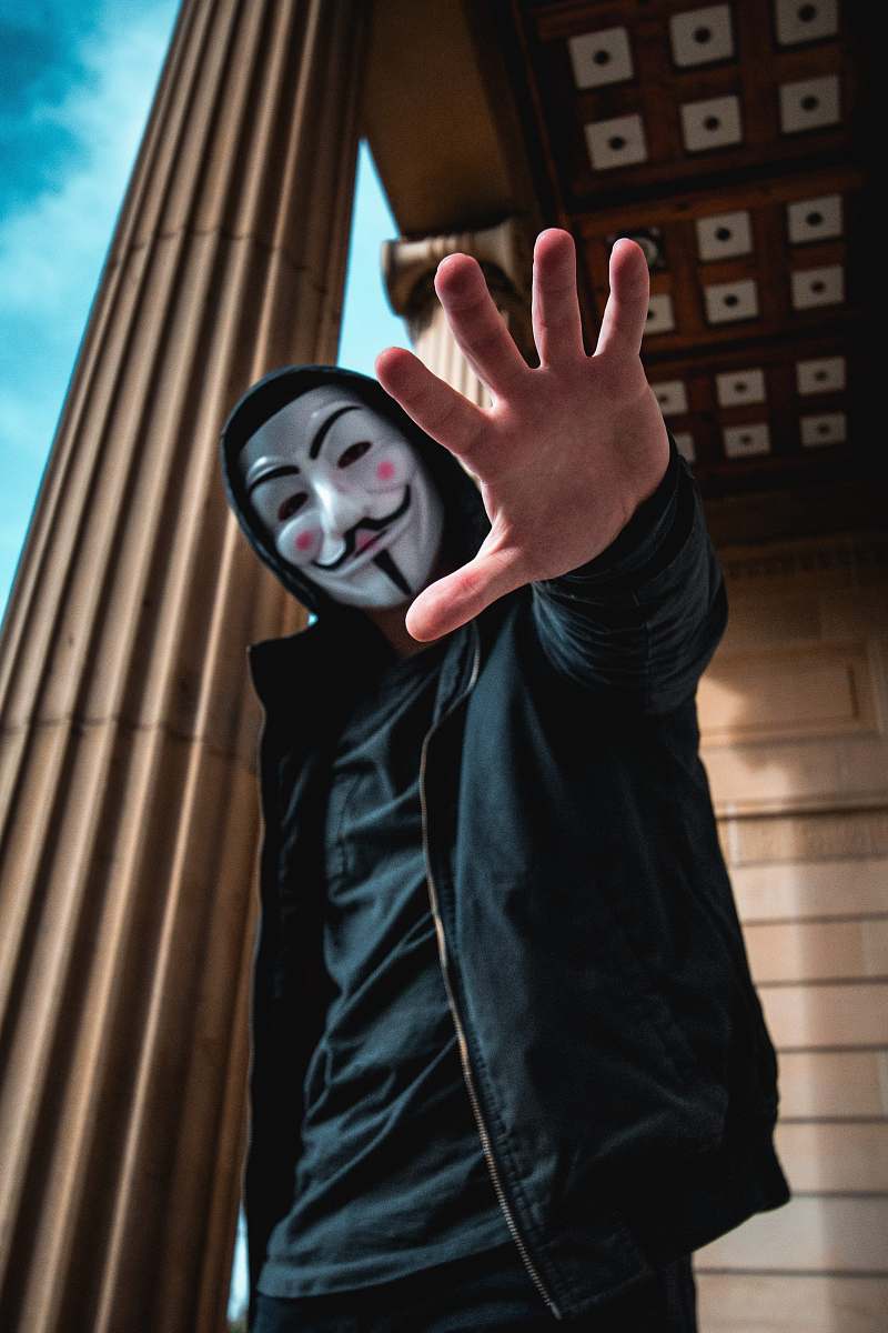 human man wearing Guy Fawkes Mask standing inside building person