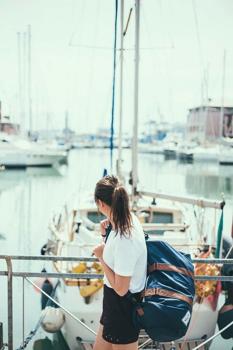 transportation woman wearing white shirt holding blue duffel bag vessel