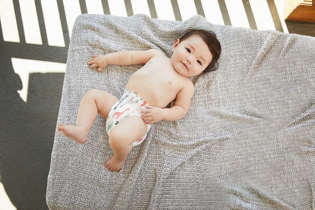 baby baby in a diaper on a gray bed newborn