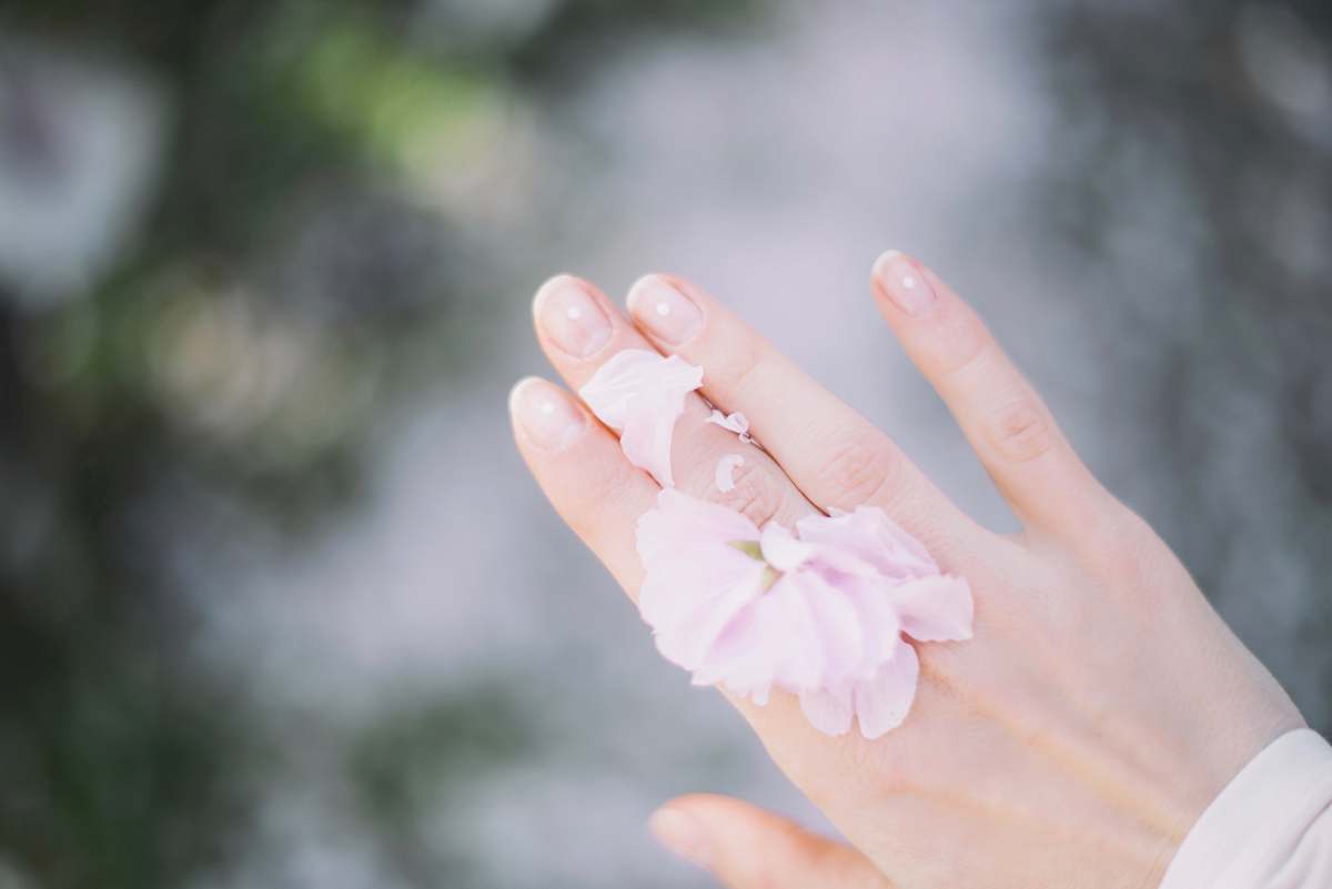 nail person with pink bow on hand selective focus photography manicure