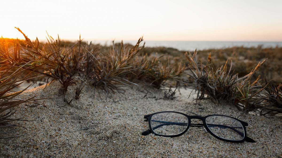mexico clear eyeglasses with black frames on sand sun