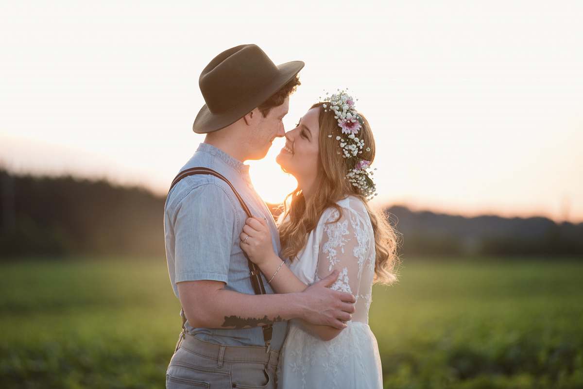 wedding couple facing each other with green grass background \ people