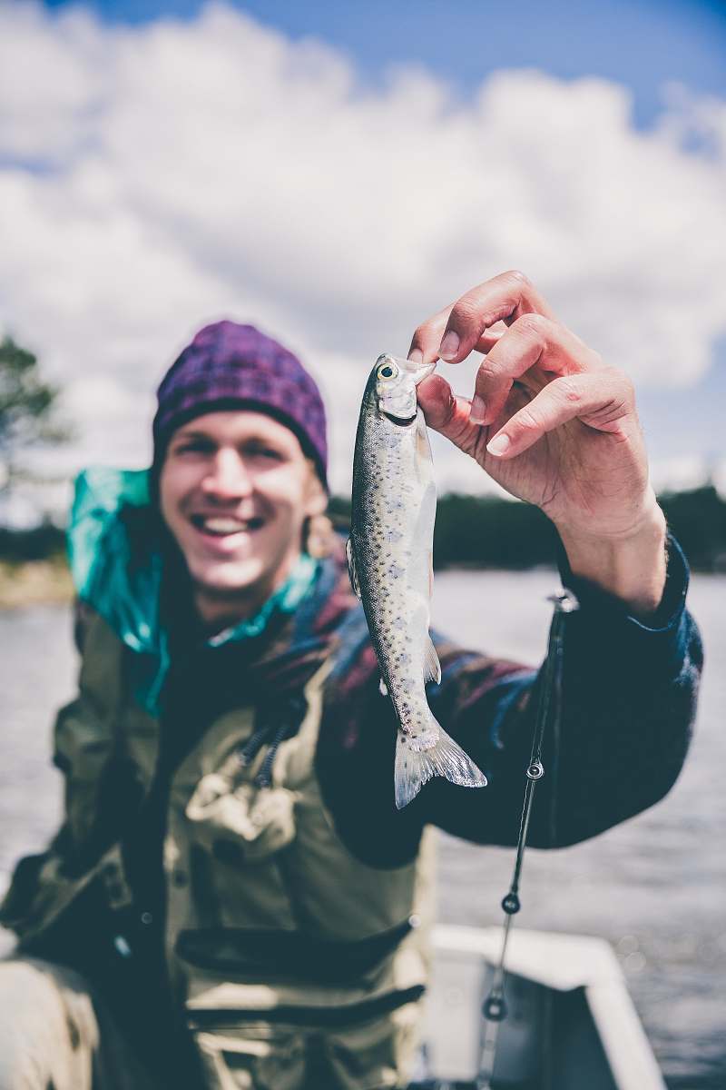person depth photography of man holding fish people