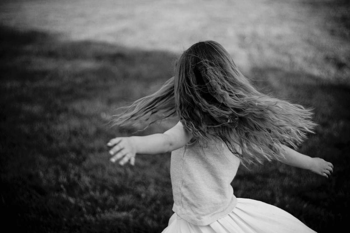 person grascale photo of a girl near grass black-and-white