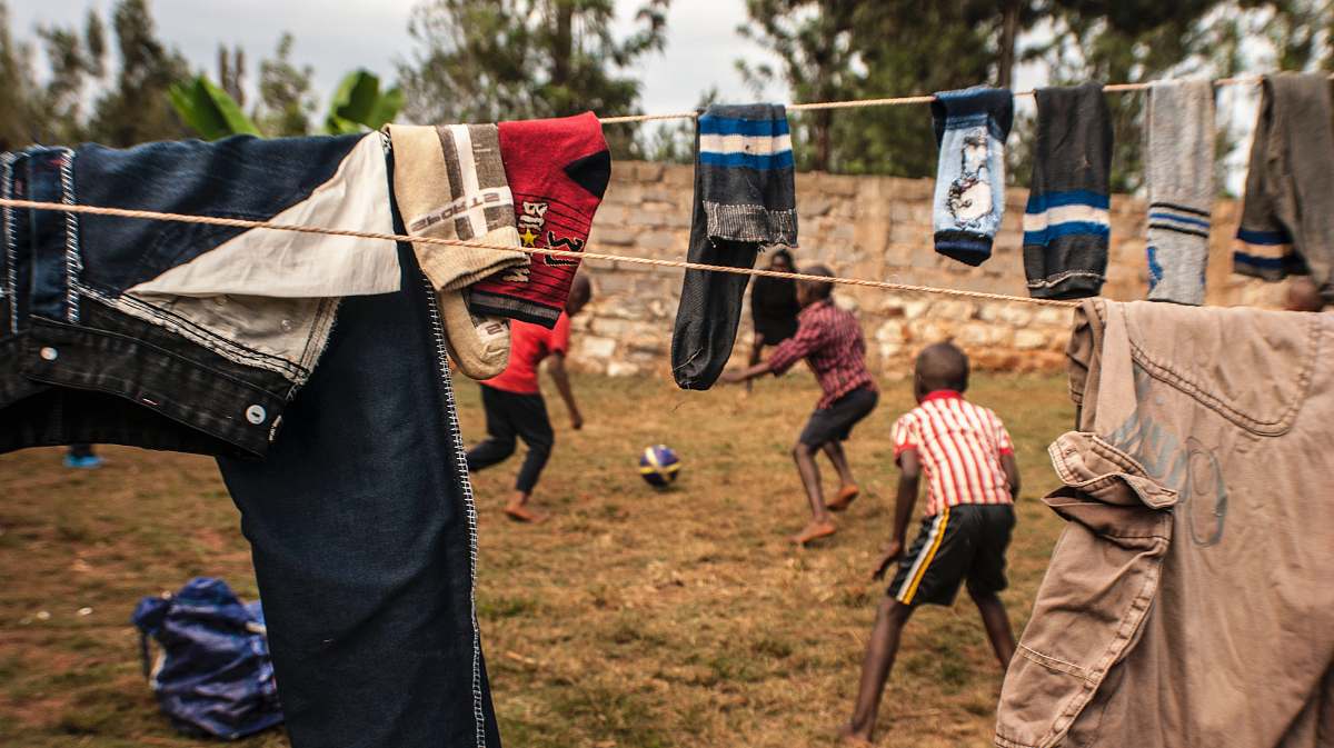 person two boys playing under clothesline kenya