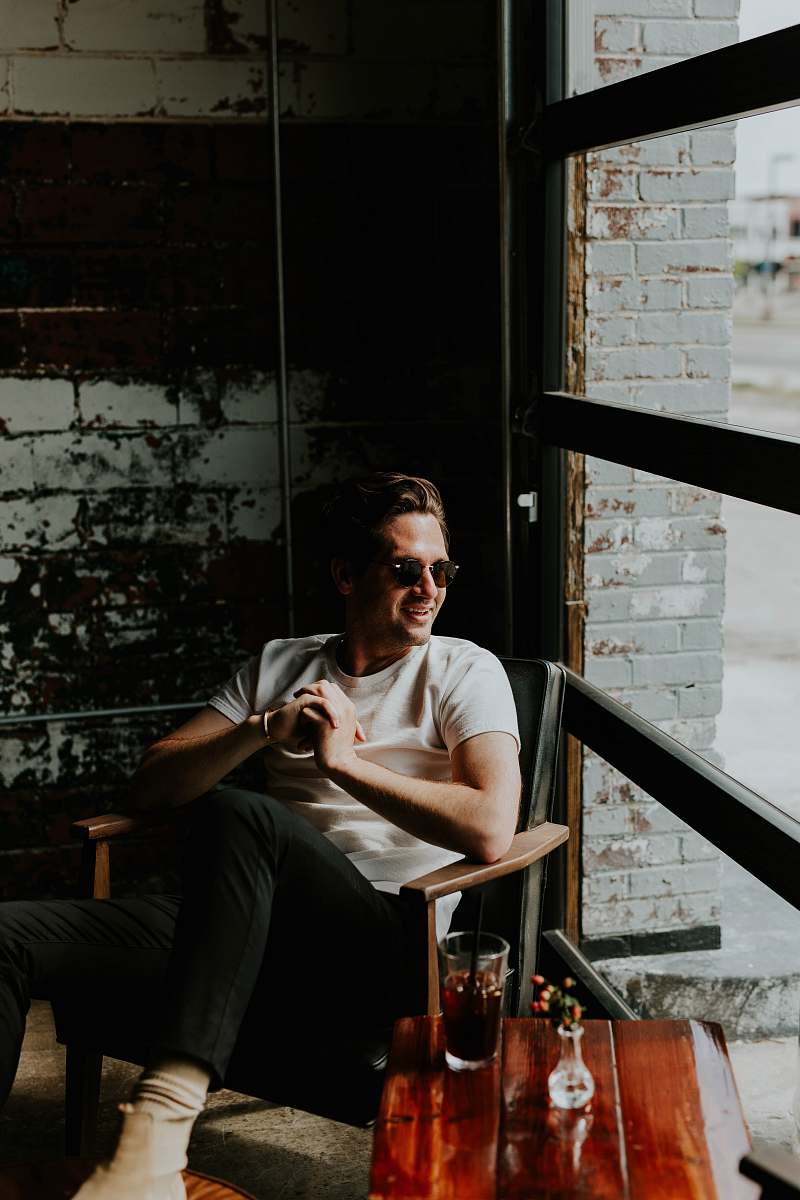 person unknown person sitting on brown armchair indoors sunglasses