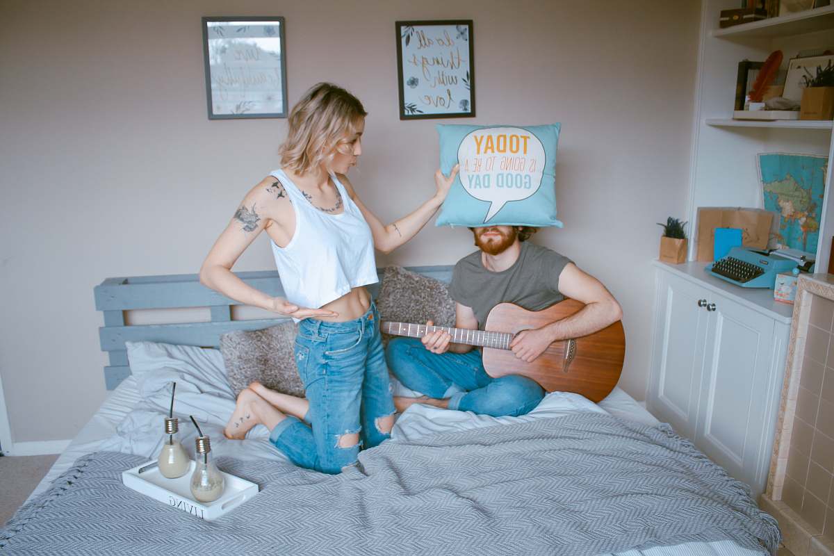 person woman and man on bed guitar