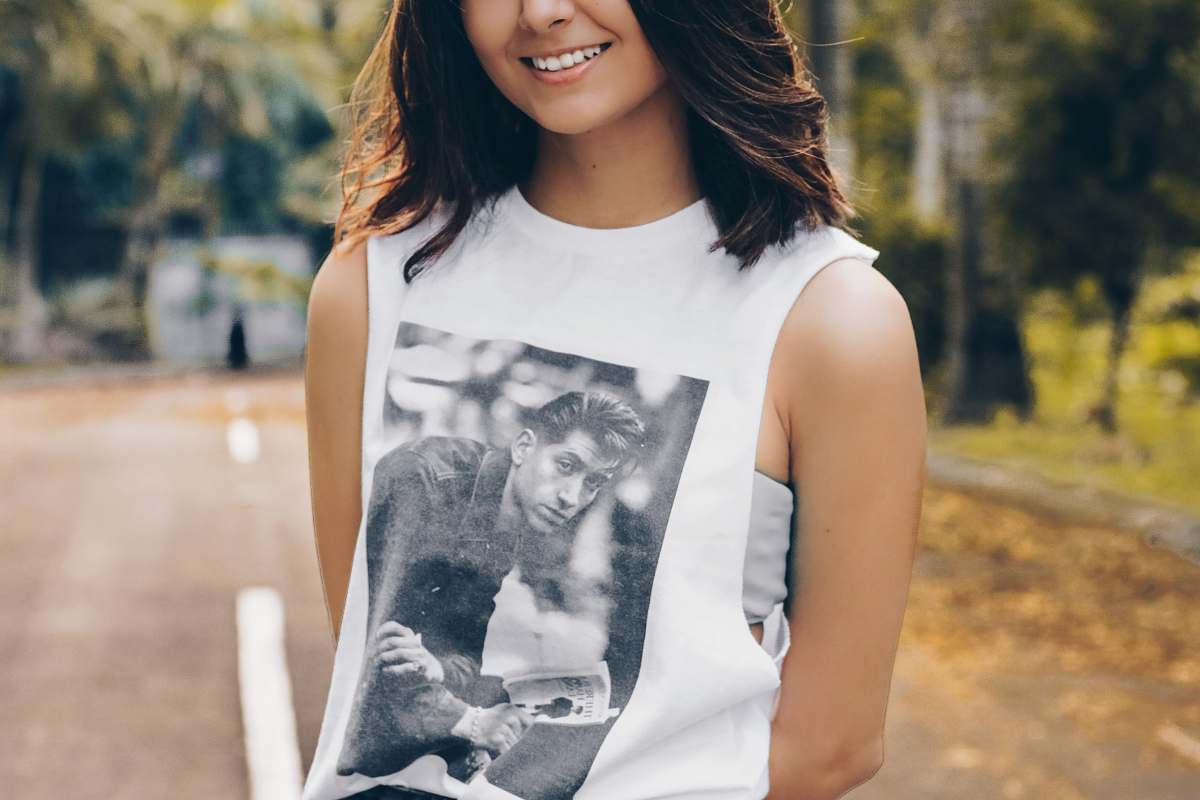 people woman wearing white sleeveless top standing on asphalt road during daytime tank top
