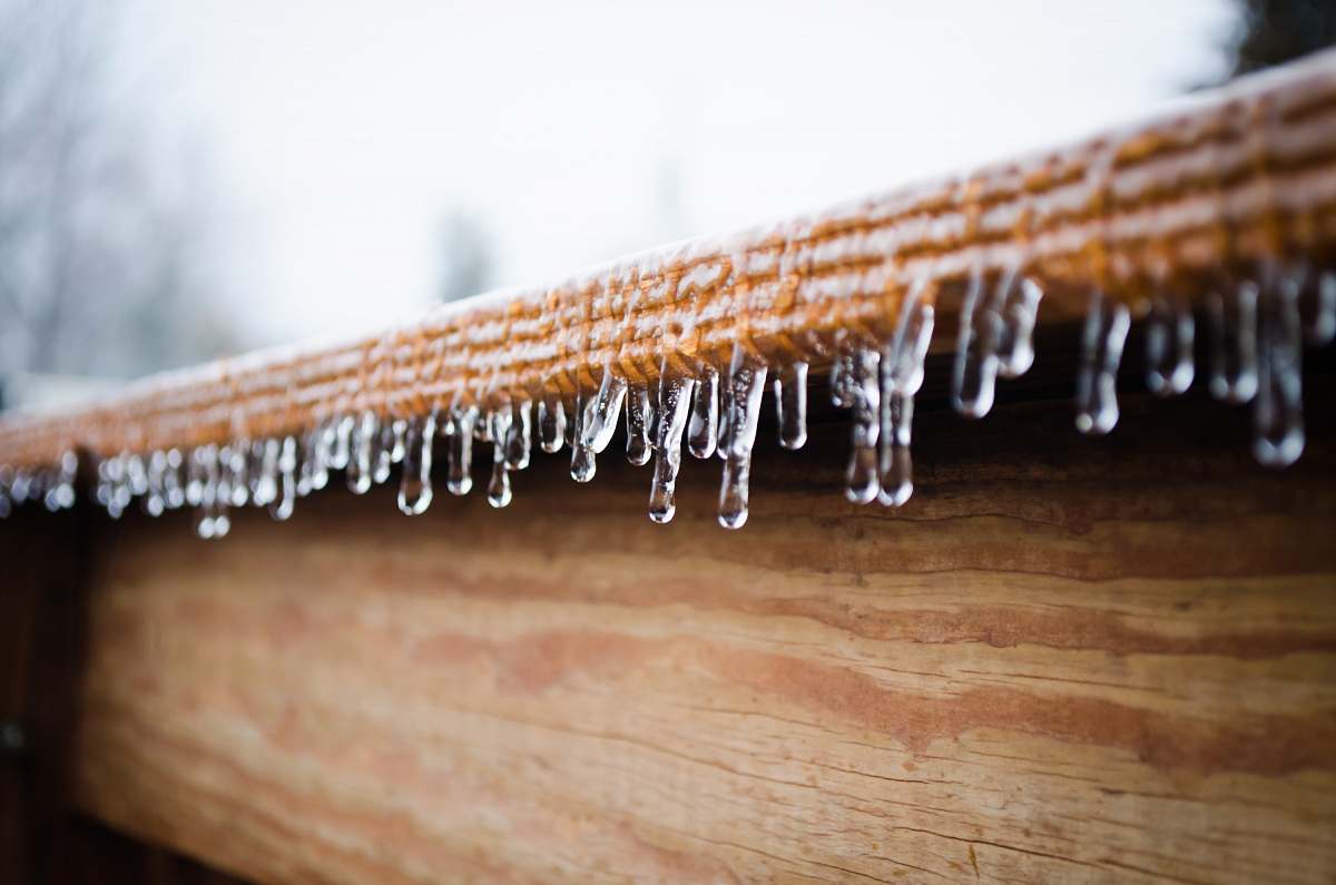 nature icicles forming at the edge of wooden panel snow