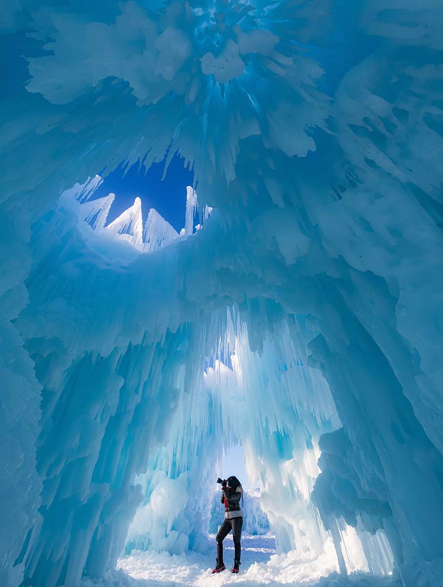 glacier woman taking photograph in ice cave snow