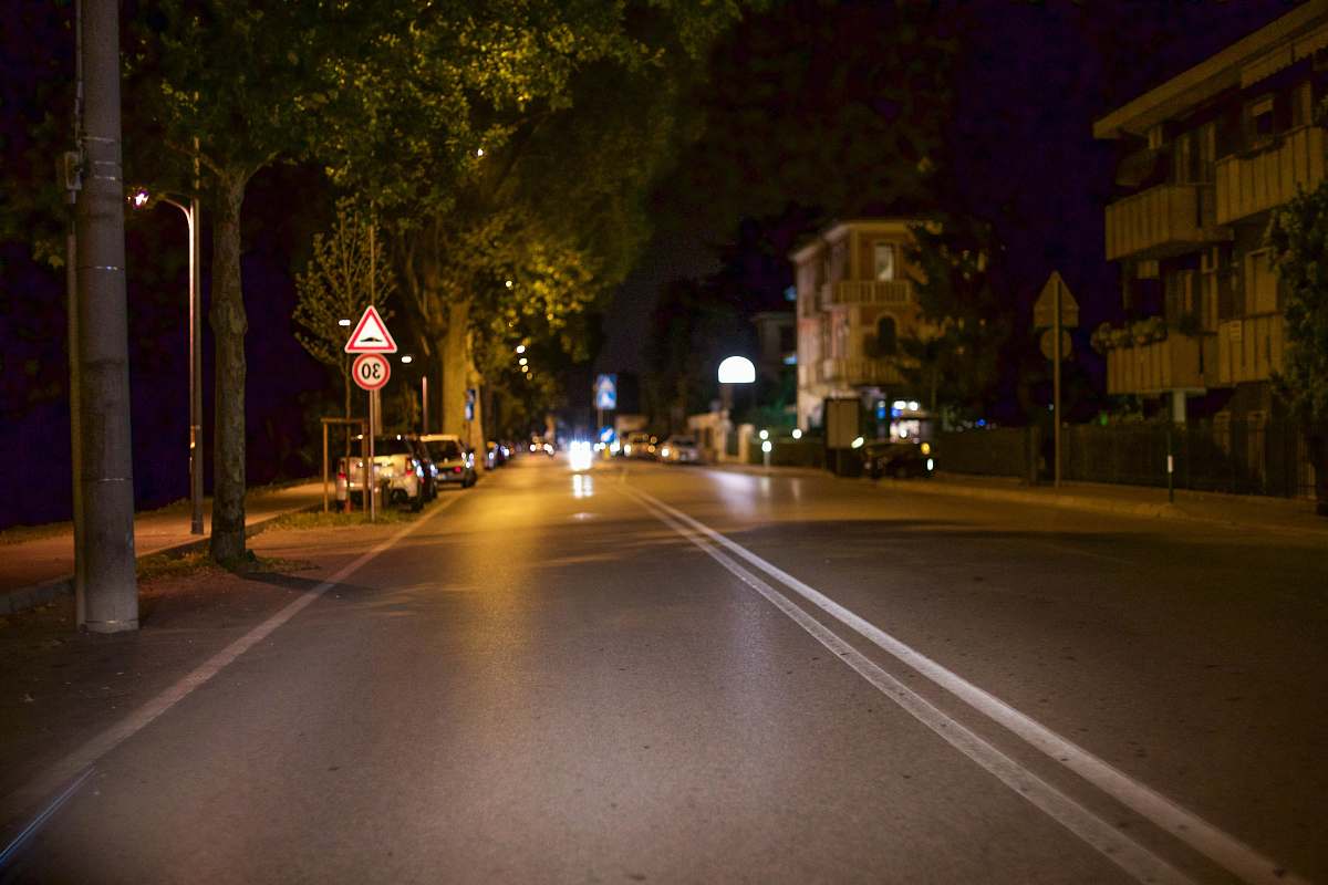 night roadway near trees and several vehicles street