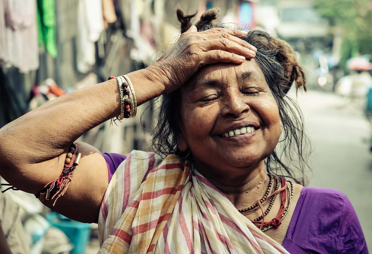woman closeup photo of smiling woman holding her forehead face