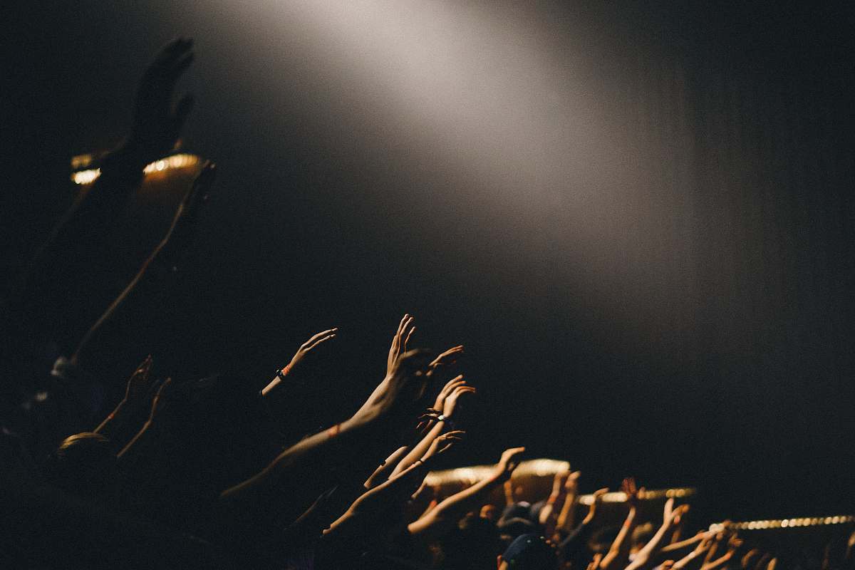 worship group of people waving their hands church