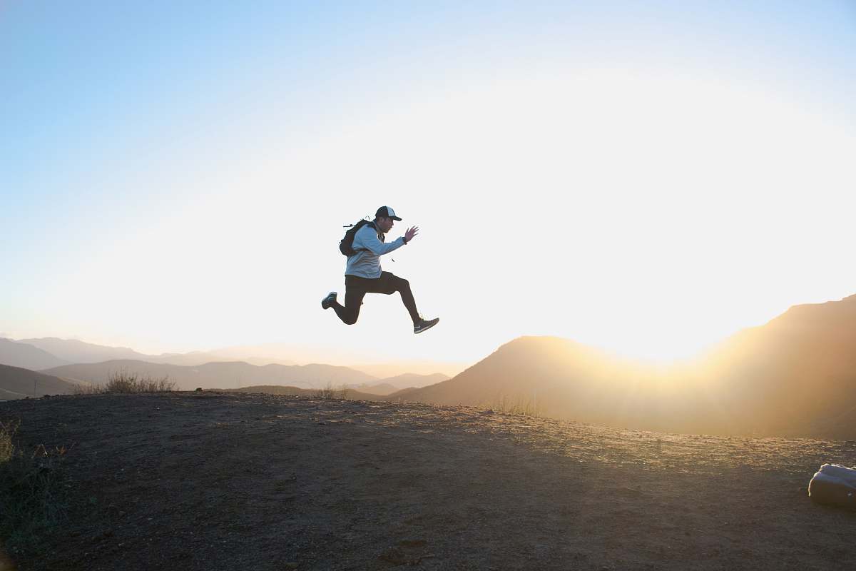 person man wearing white long-sleeved shirt on air photo jump