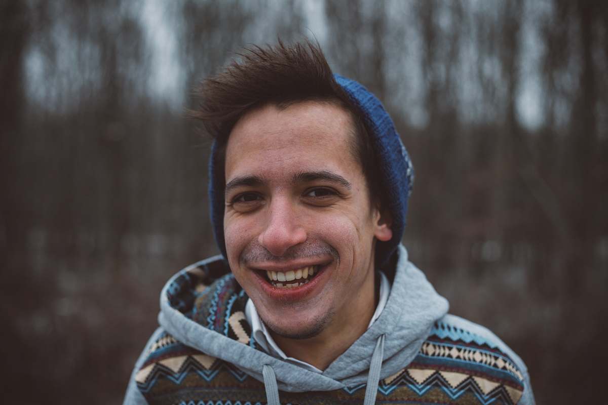 person shallow focus photography of a man smiling while taking picture human