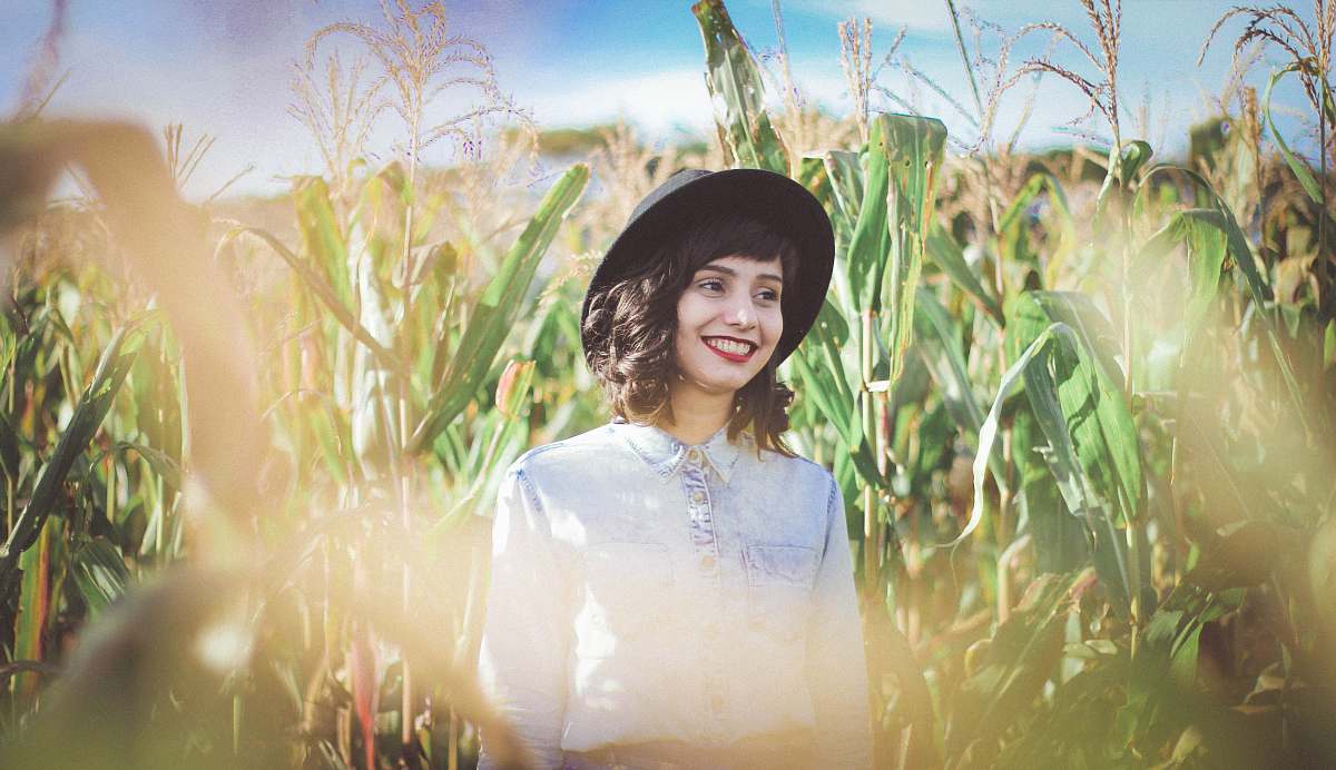 person woman in blue denim top standing on cornfield girl