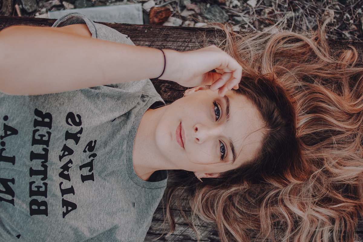 girl woman wearing gray t-shirt lying on ground portrait