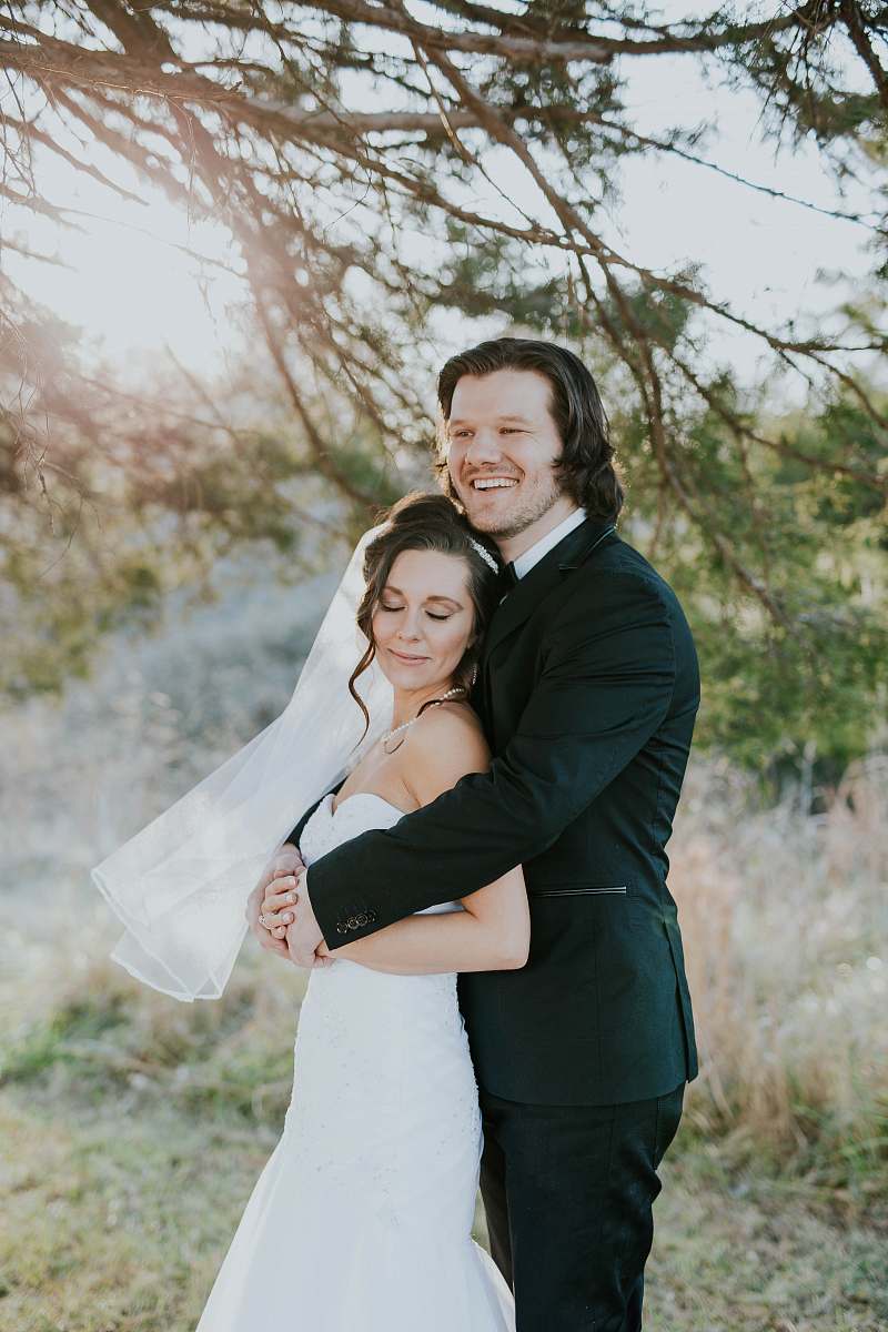 people bride and groom standing beside green leafed tree during daytime wedding