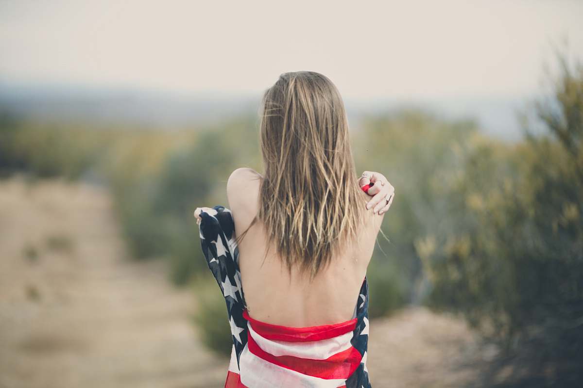 human focus photography of half naked woman covering body with USA flag woman
