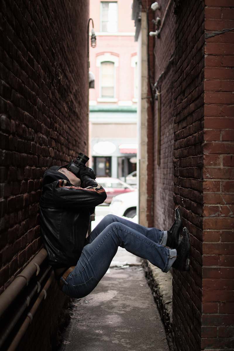 human person holding black camera taking a photo while looking up people