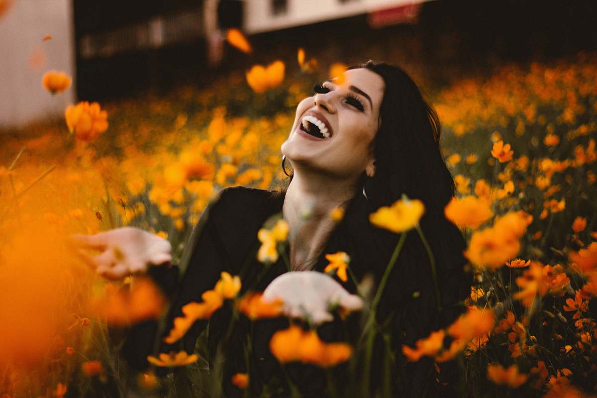 human woman laughing on flower field face