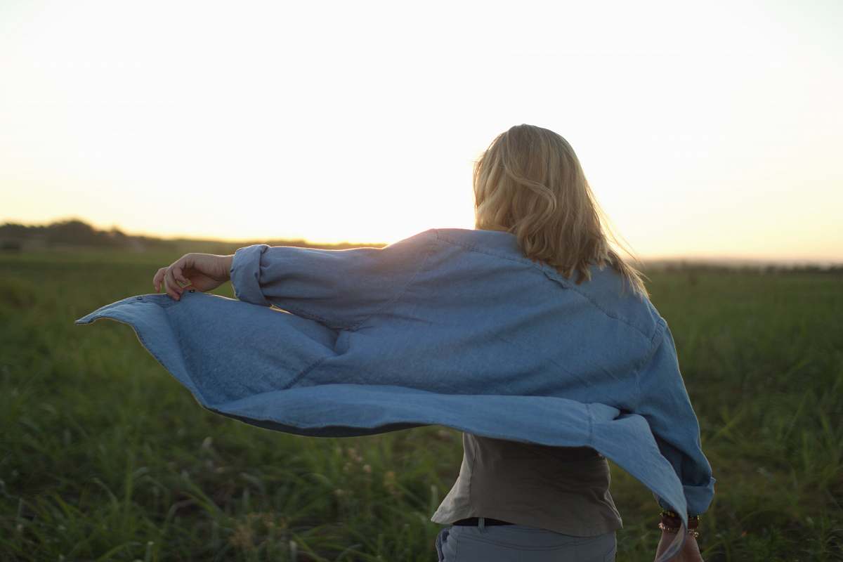 woman woman walking in the middle of grass field people