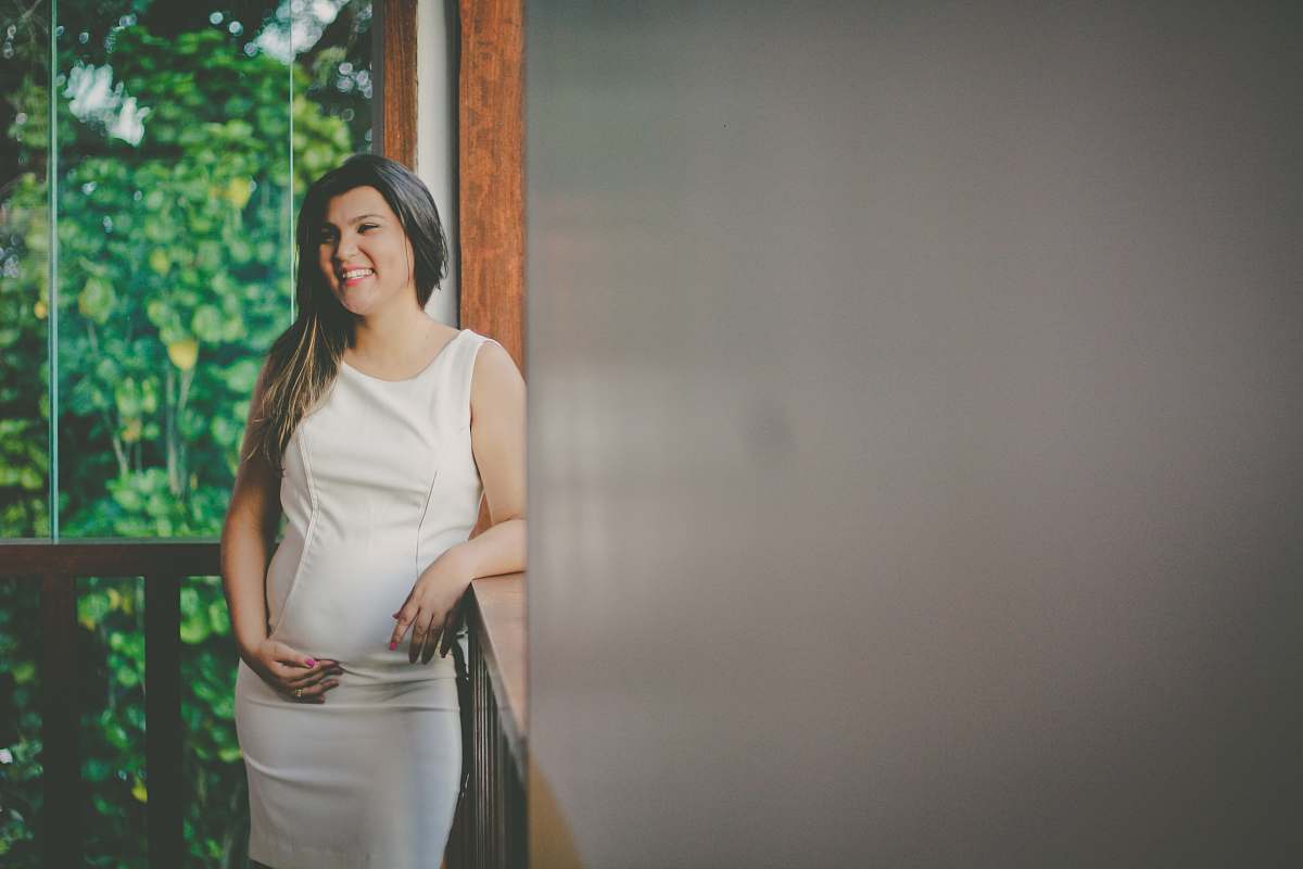people woman wearing white sleeveless dress leaning on brown wooden baluster inside room human