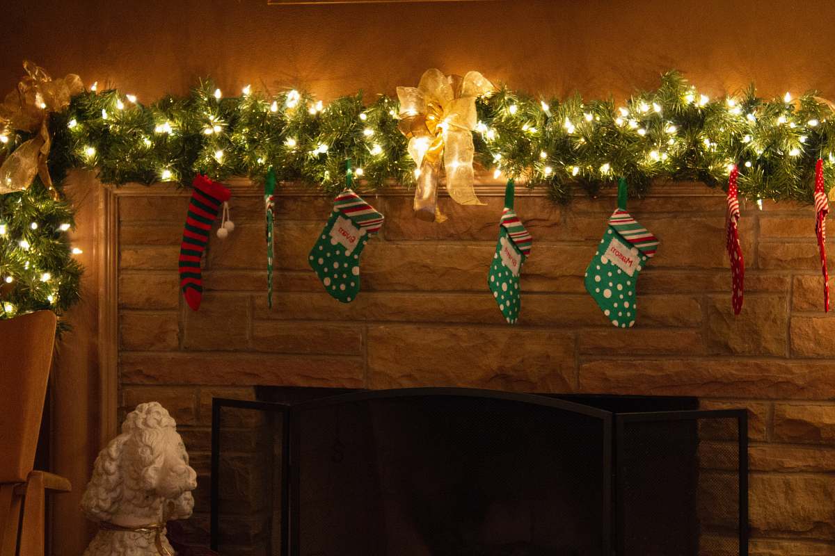 tree string lights with christmas socks on wall indoors