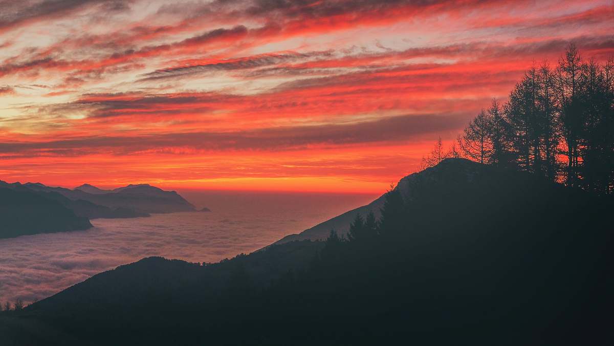 sunset silhouette photo of mountain near body of water during sunset sunrise