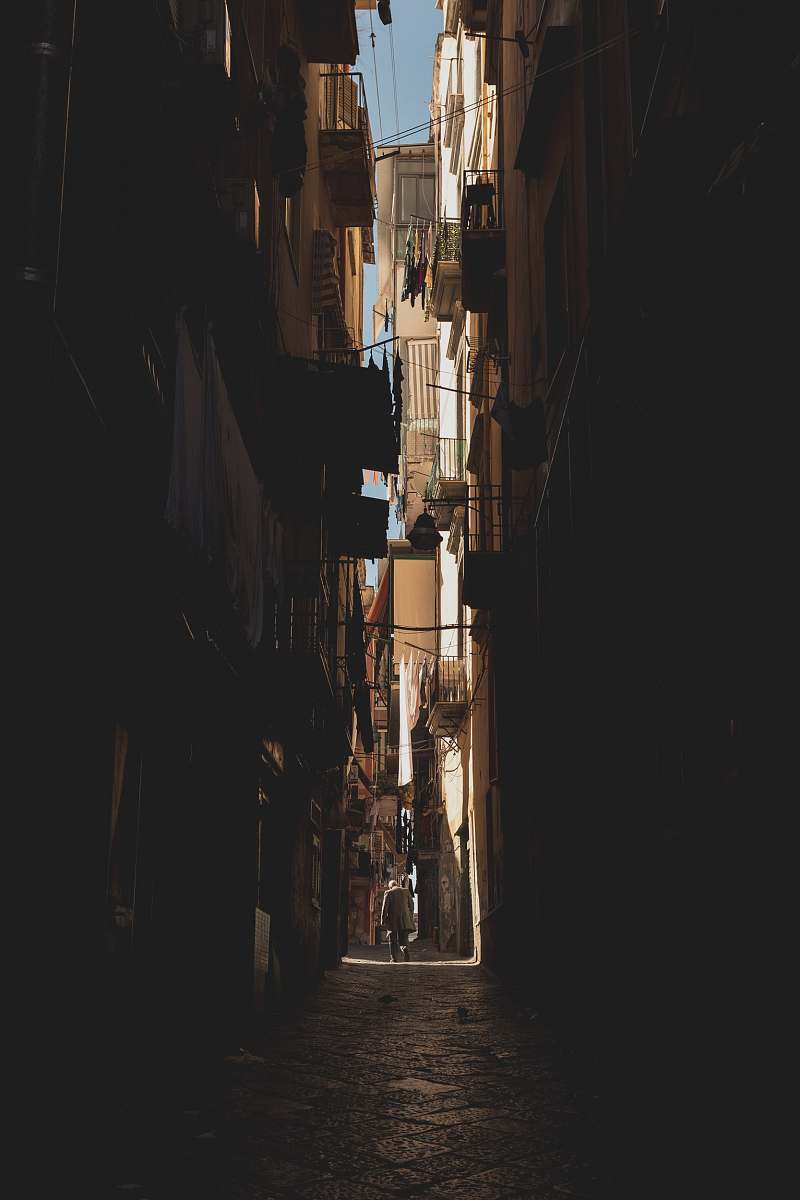 alley person walking in middle of buildings alleyway