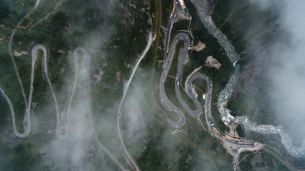 drone bird's eye view photography of curved pave road road