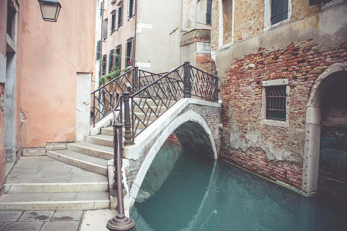 italy architectural photo of concrete buildings and bridge during daytime building