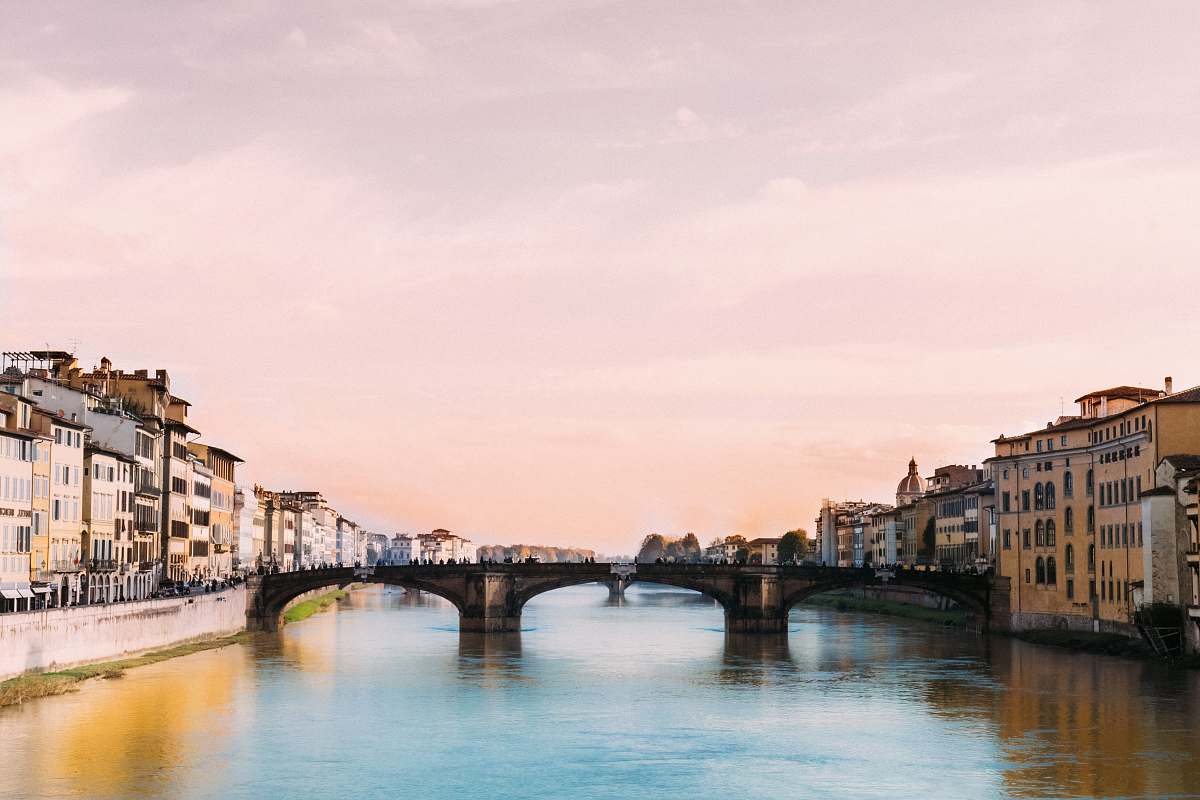 canal bridge crossing river in town under cloudy sky during daytime bridge