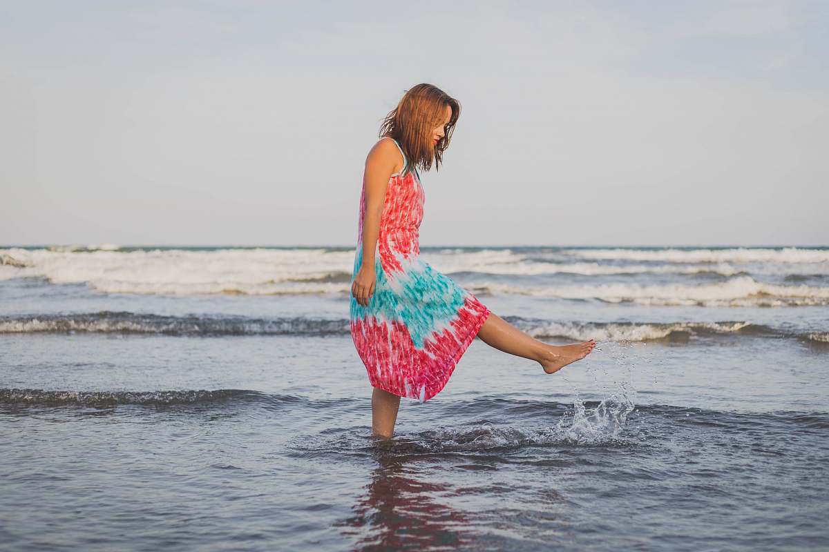 beach woman playing with water on shore during daytime coast