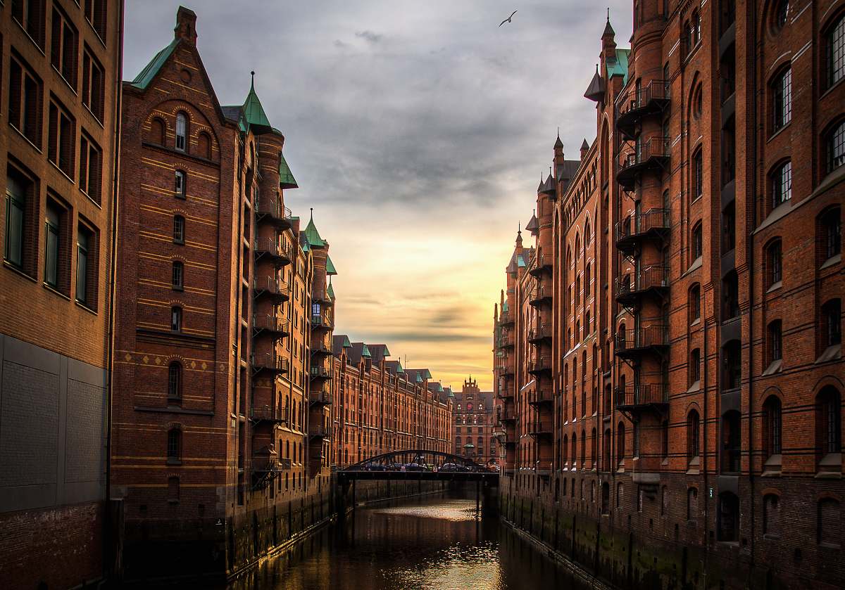 building river between brown concrete buildings canal