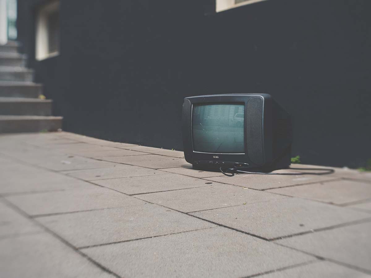 television turned off black CRT TV near black concrete wall tv