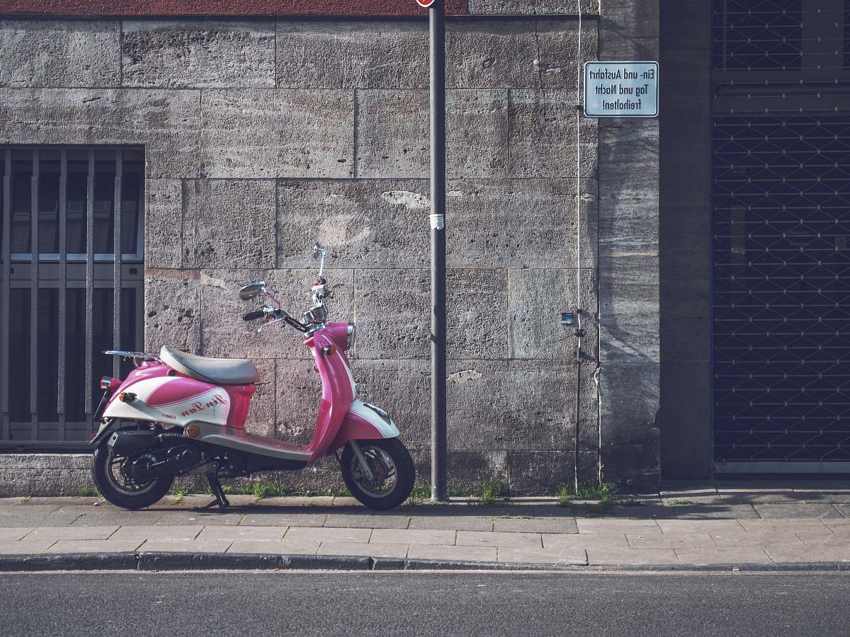 vehicle parked pink motor scooter motorcycle