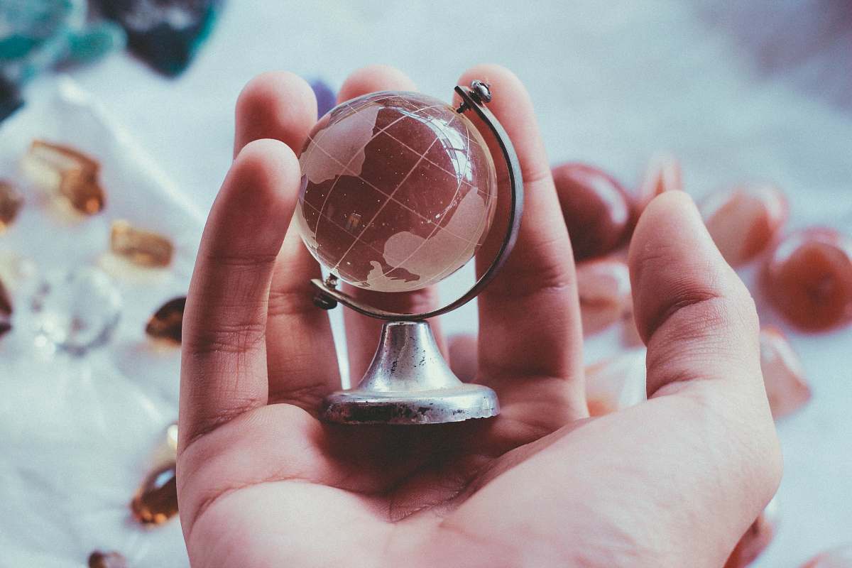 glass person holding gray metal framed desk globe paper weight prism