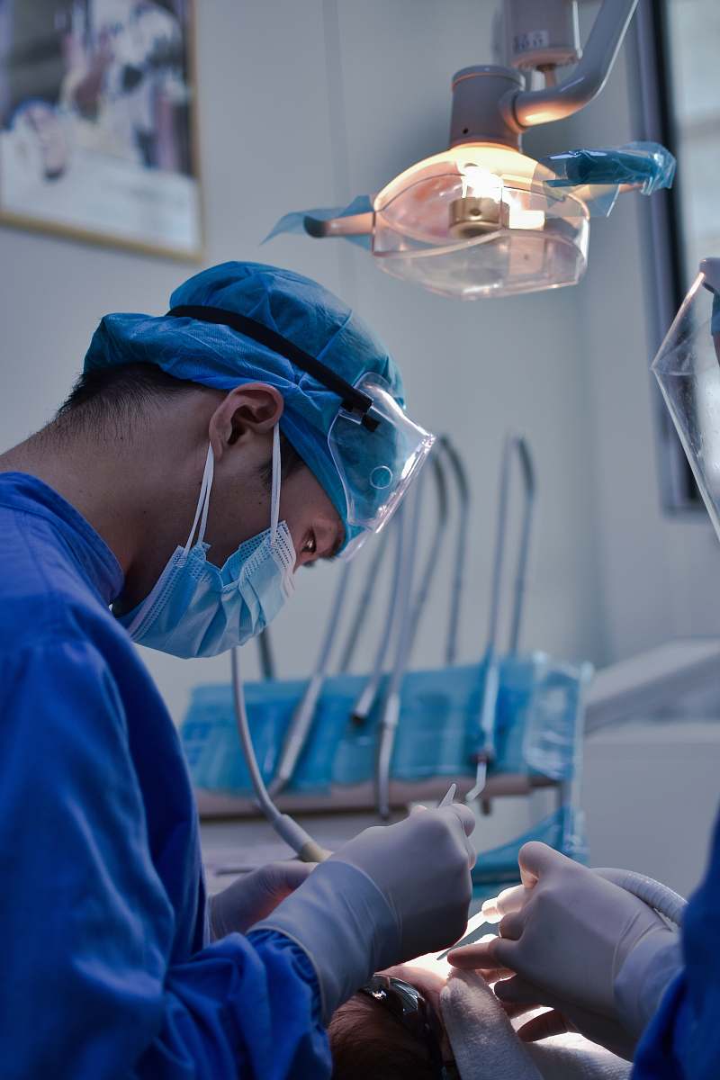  person in blue scrub suit holding clear glass cup 