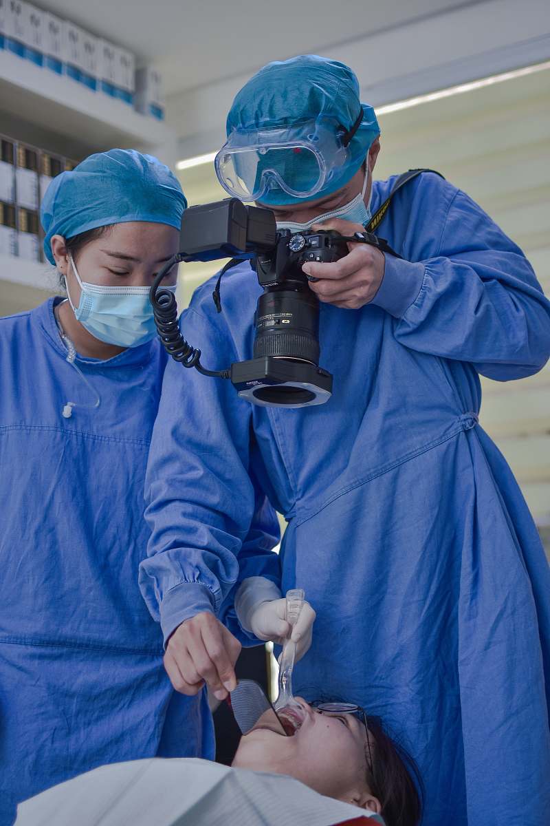 clothing man in blue zip up jacket holding black dslr camera helmet