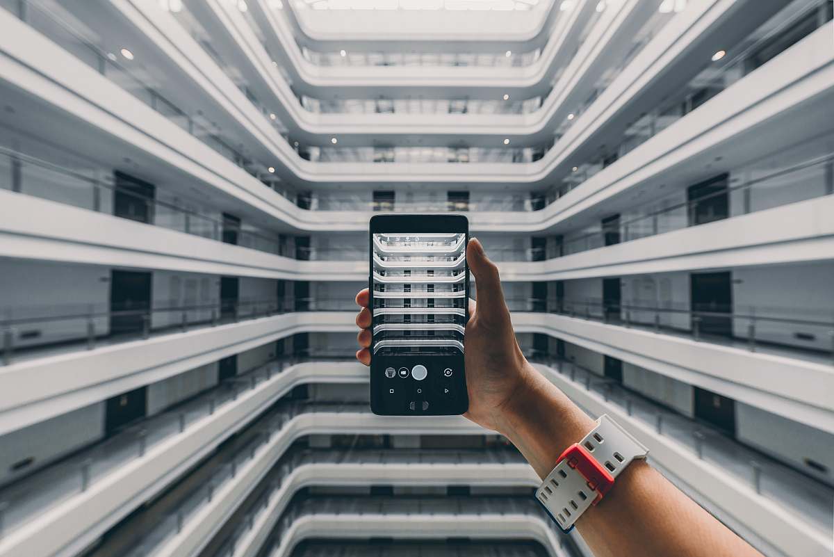 building person taking photo of building during daytime housing