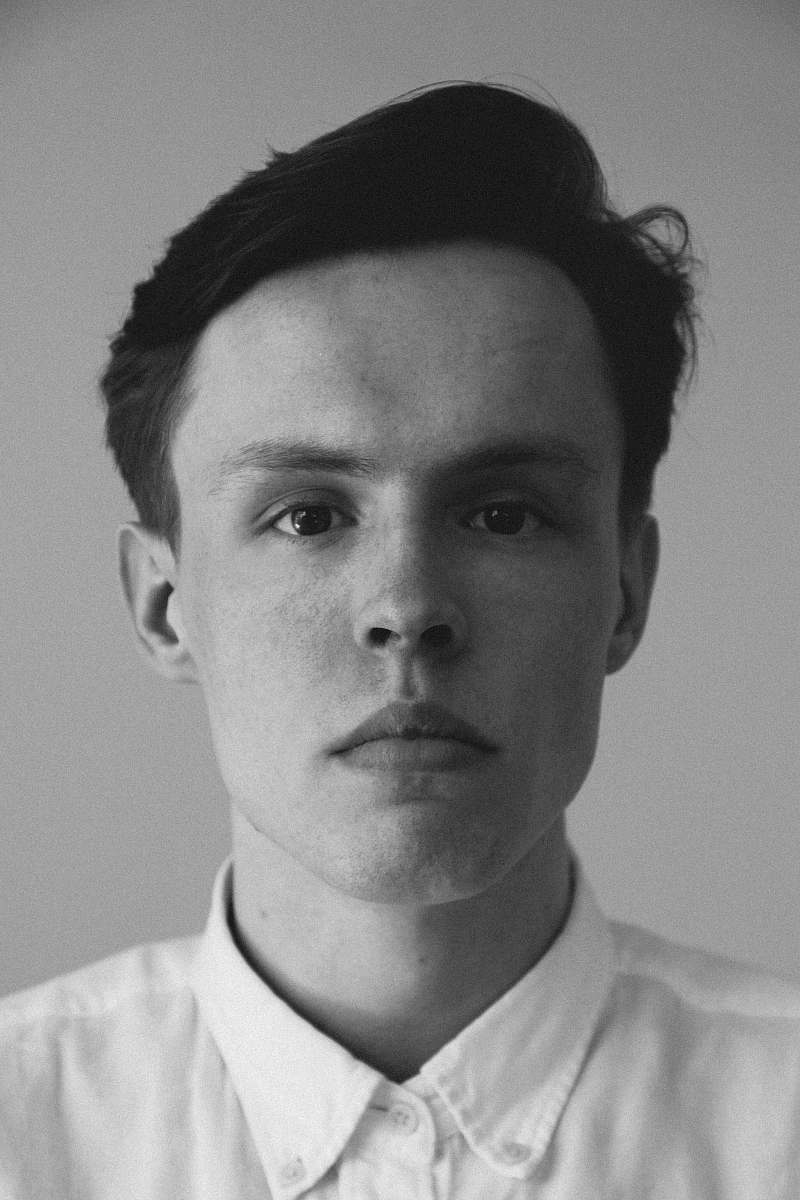 head grayscale photography of man wearing collar top face