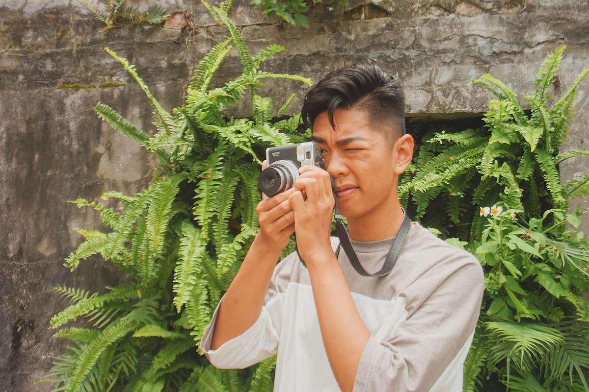 person man takes photo near plants human